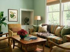 Green living room with traditional furnishings in neutral tones. 