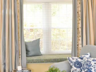 Window Seat With Blue and Beige Striped Drapes and Blue Cushion