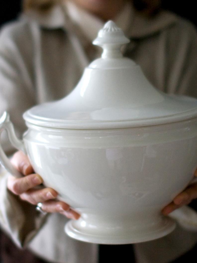 Woman Holding White Covered Dish