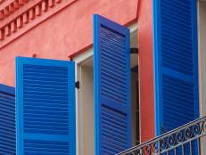 Striking Blue Shutters and Red Wall