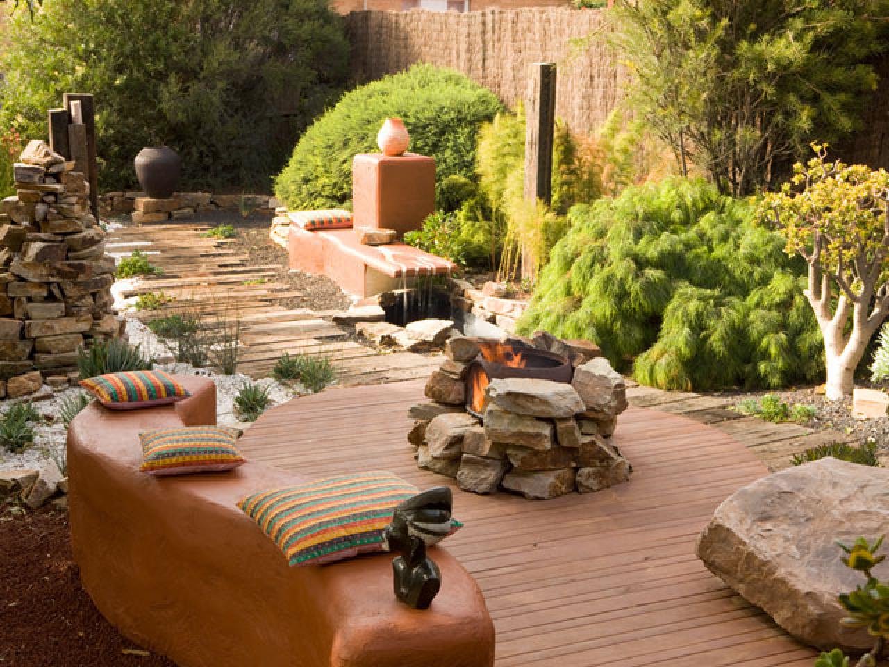 an image of a fire pit surrounded by stone on a deck within a garden