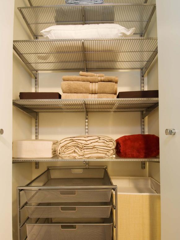 Closet With Metal Shelving Holding Towels, Bed Linens and a Pillow