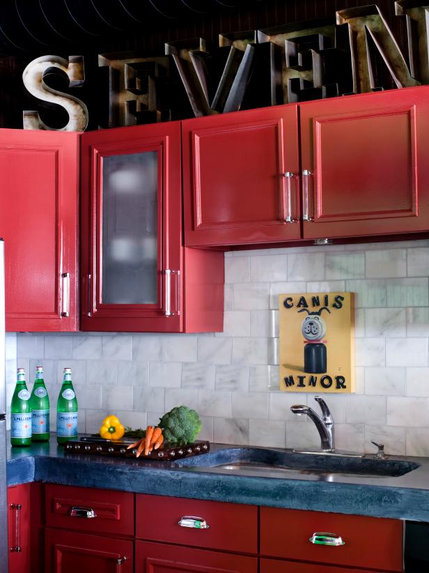 Kitchen With Blue Counters, White Tile Backsplash and Red Cabinets