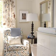 Cream Colored Nursery With Changing Table and Polka Dot Chair
