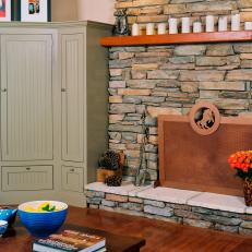 Country Living Room With Stone Trimmed Fireplace and Copper Screen