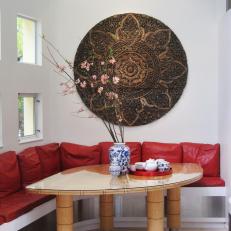 Asian Breakfast Nook With Red Banquette and Metal Wall Art