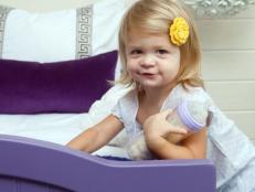 Girl in bedroom with purple bed