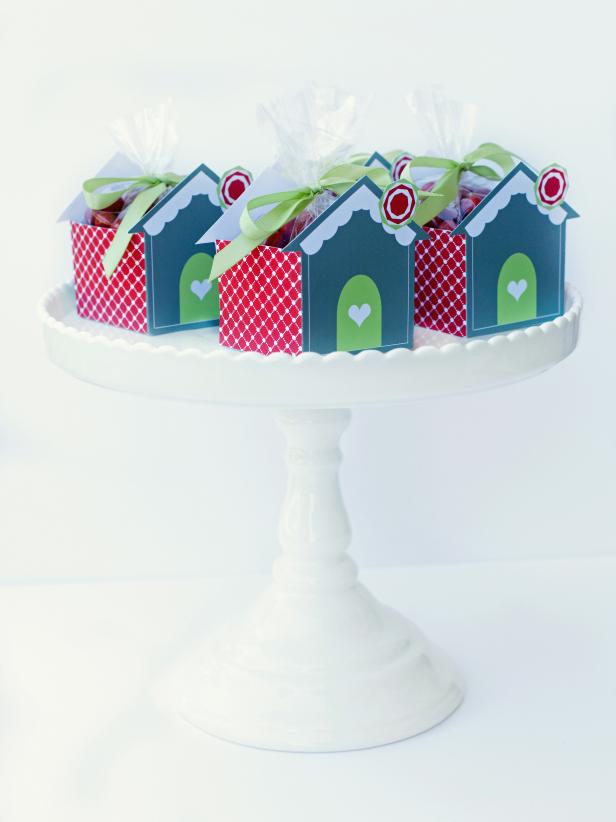This box template is the perfect vessel for take-home treats at the end of your gingerbread house party. Since guests are heading home after feasting on a bounty of sweets, fill with trinkets and toys instead of more sugary treats. Or, use the favor boxes to house sweet treats for teachers, friends and neighbors.