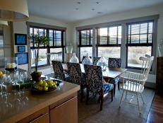 Open Kitchen and Dining Area With Patterned Chairs and Large Windows