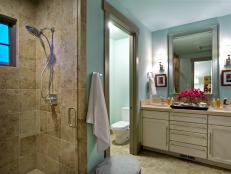 A private guest bathroom offers up a cool, calming palette and luxurious amenities.