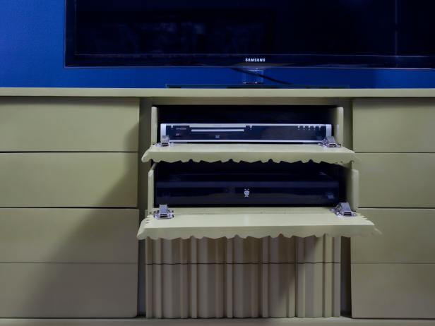 An old dresser was reinvented as a designer-grade media console by outfitting drawer fronts with hinges, and using a paint sprayer to add a high gloss finish.