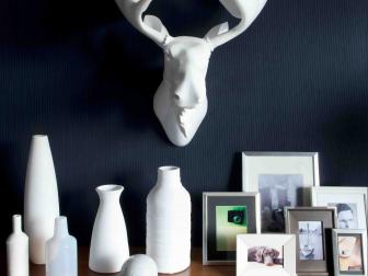 White Faux Moose Head on Dark Wall Above White Vases, Frames