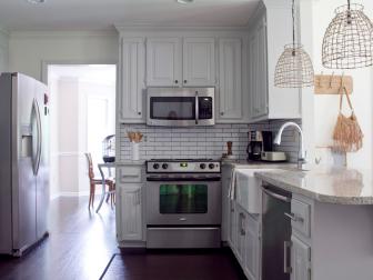 Small White Kitchen With Stainless Steel Appliances and Subway Tile