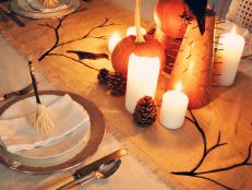 Add a rustic touch to your Halloween table setting with a burlap runner decorated with ghostly bare branches and ravens.