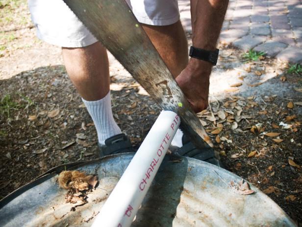 Once the drain pipe diameter measurement is determined, cut a piece of PVC pipe approximately 30 inches long using a hand saw. Place PVC pipe vertically on one end, in the middle of the brick.