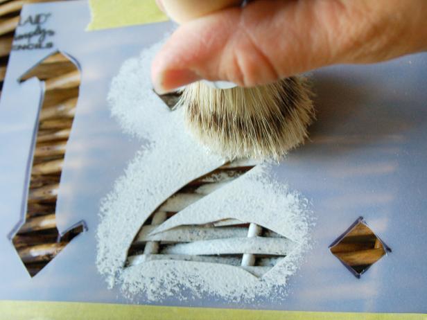 Hold brush perpendicular to basket surface and apply paint with a pouncing motion. Remove stencil and allow paint to dry.