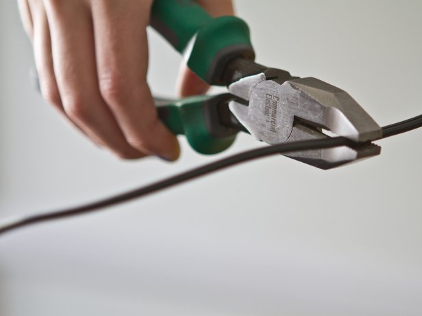 Woman cutting wire from lamp. 