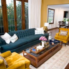 Chic Living Room With Blue Tufted Sofa and Gold Velvet Chairs