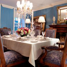Traditional Blue Dining Room With Ornate Chandelier and Fancy Table Setting