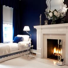 Navy Blue Bedroom With White Fireplace and Chaise Lounge