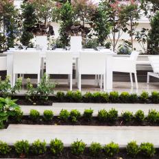 White Contemporary Outdoor Dining Room With Lush Greenery