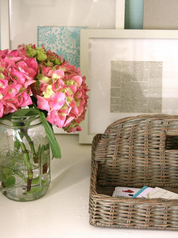 White Desk With Old Basket and Glass Jar of Pink Flowers