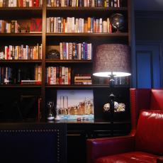 Home Office With Dark Wood Bookshelves and Red Leather Chair