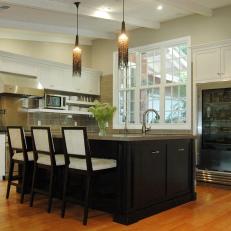 Neutral Kitchen With Black Island and Built-In Refrigerator 