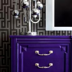 Purple Dresser With Silver Hardware and Modern Lamp