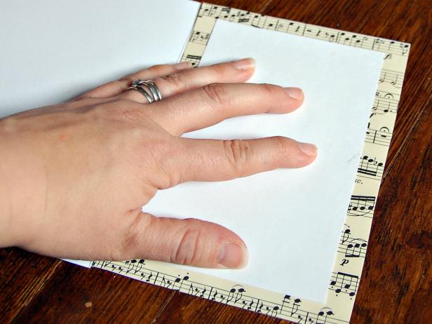 Prepare the inset of the card to write a message on by gluing a blank piece of white paper to the sheet music backing.