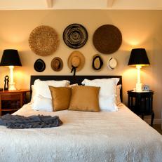 Cottage-Style Bedroom with a Collection of Straw Hats Hung Above the Bed