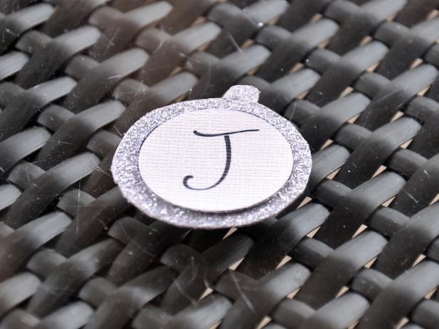 Once you have glued the white paper to the ornament, you'll have a sparkly and decorative letter J.