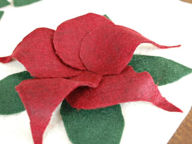 Stick the base of the petal in the center of the poinsettia, gently fold up and stick tip of petal to pillow, allowing it to arch slightly.