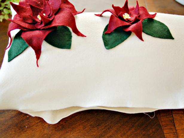 Red and Green Felt Poinsettias Sewn onto Fabric