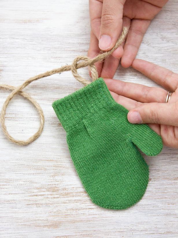 Unravel a piece of twine longer than the length of your mantel and thread each of the mittens onto it.