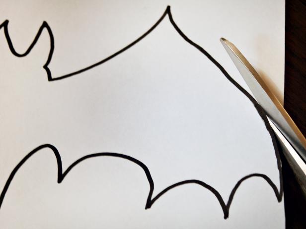 A bat stencil is cut out for a Halloween applique pillow.