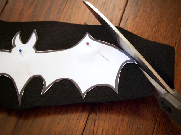 A bat design is cut out from black felt to be added to a Halloween applique pillow.