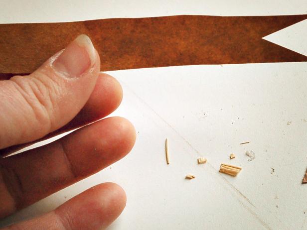 Measure and cut a 3&quot; x 3/4&quot; pennant-shaped piece out of a brown paper bag and cut a small triangle out of right end.