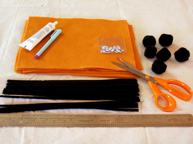 Supplies are laid out to make Halloween themed spider napkin rings.