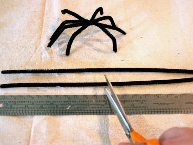 Pipe cleaners are used to form the legs for Halloween napkin ring spiders.