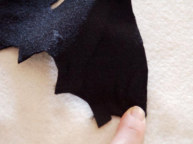 Black bat designs are glued to a Halloween applique pillow.