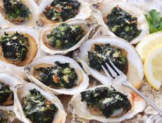 Oysters Rockefeller with lemon slices and fork