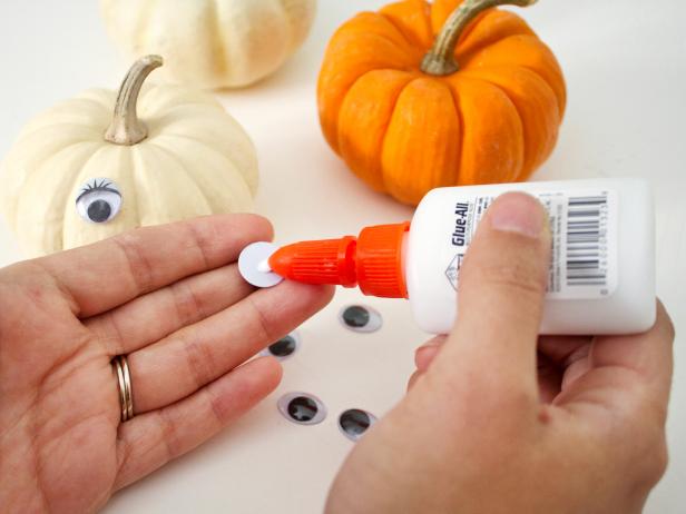 Apply craft glue to the backs of your googly eyes before attaching them to the pumpkins.