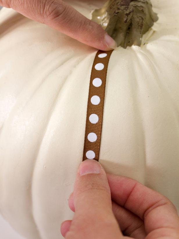 Unroll the ribbon all the way down one groove of the pumpkin until it reaches the bottom of the pumpkin.