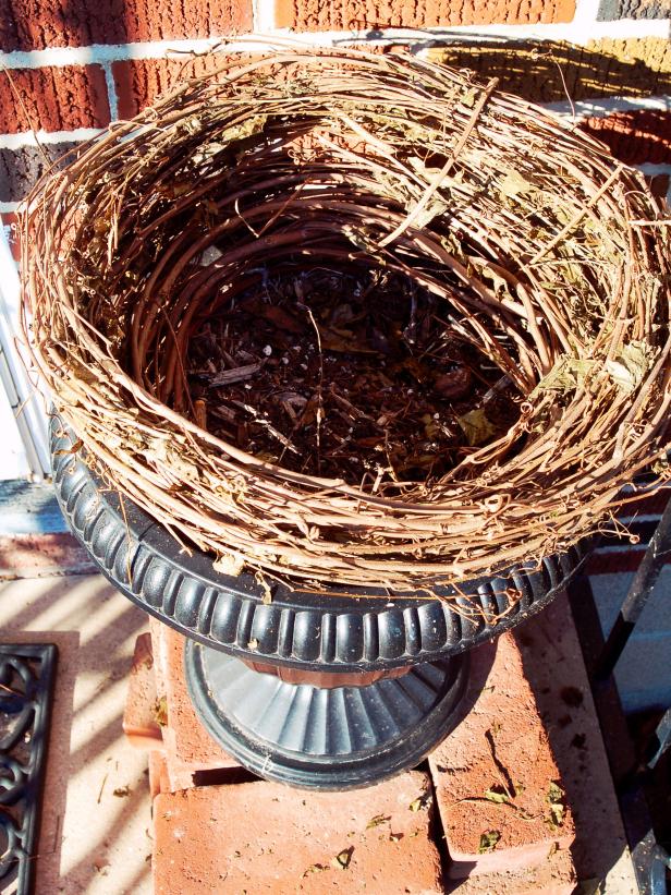 Gently pull apart with fingers. Position large wreath inside top of urn to make a nest for large pumpkin.