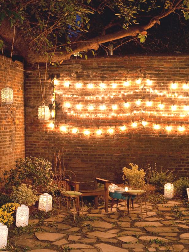 String Lights Along Brick Wall in Backyard Garden Area