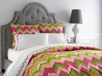 Gray Upholstered Bed With Bright Pink & Green Patterned Bedding