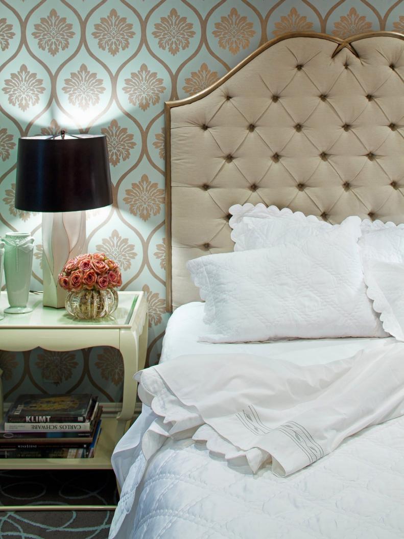 Bedroom With Blue and Gold Pattern Wallpaper and Tufted Headboard