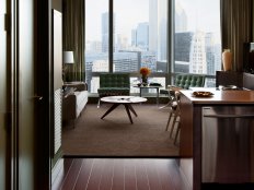 Neutral Family Room With Tufted Green Chairs and Picture Windows 