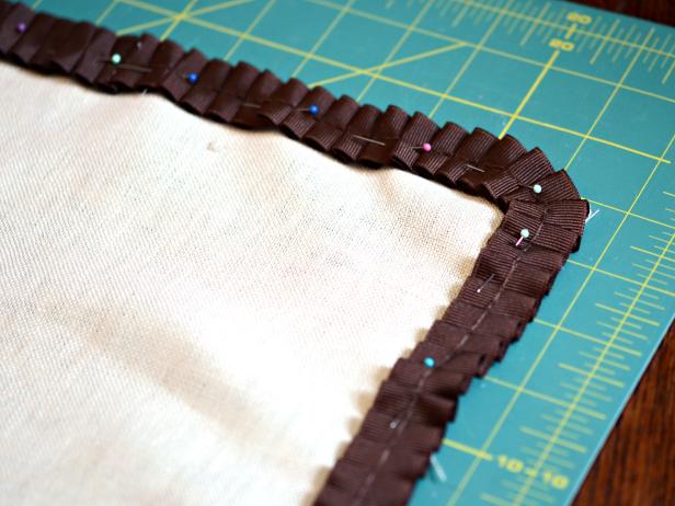 Position and pin pleated ribbon trim around perimeter pillow front.